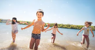 Enfants qui jouent dans l'eau au bord de la plage du Lac de Bairon